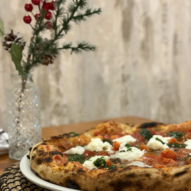 Pizza con burrata e pomodorini servita al tavolo
