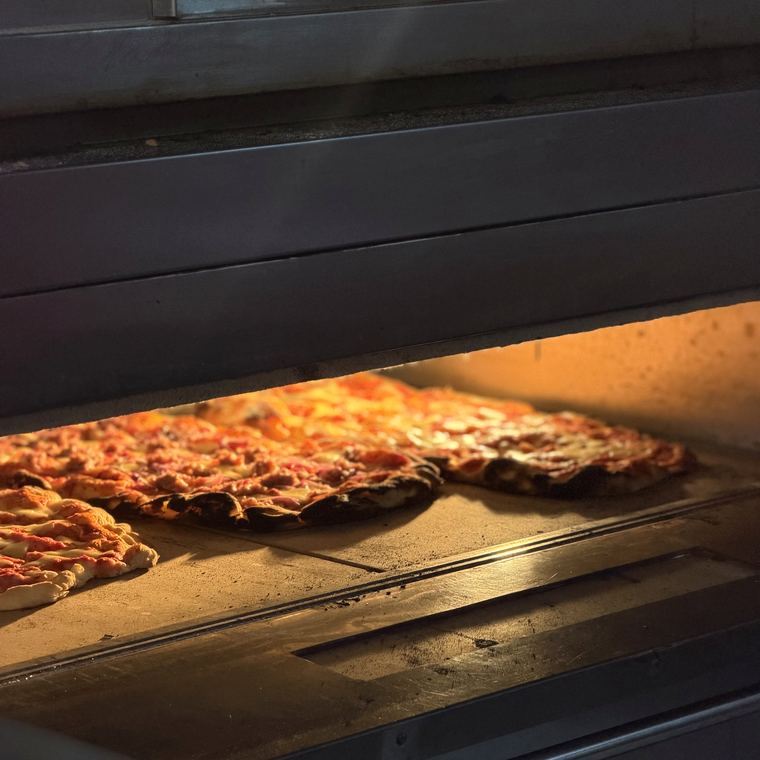 Pizze in cottura sul piano del forno
