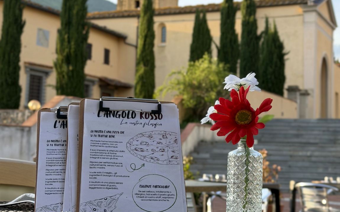 Tavolo apparecchiato all'aperto con il campanile sullo sfondo